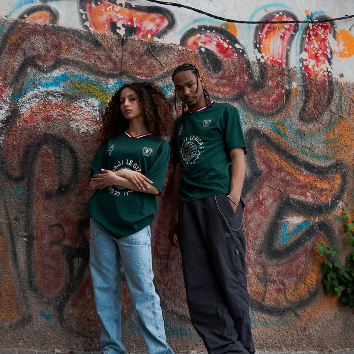 Full body view of the models wearing the Dark Green Le Giza Football Jersey, showcasing its boxy unisex fit.