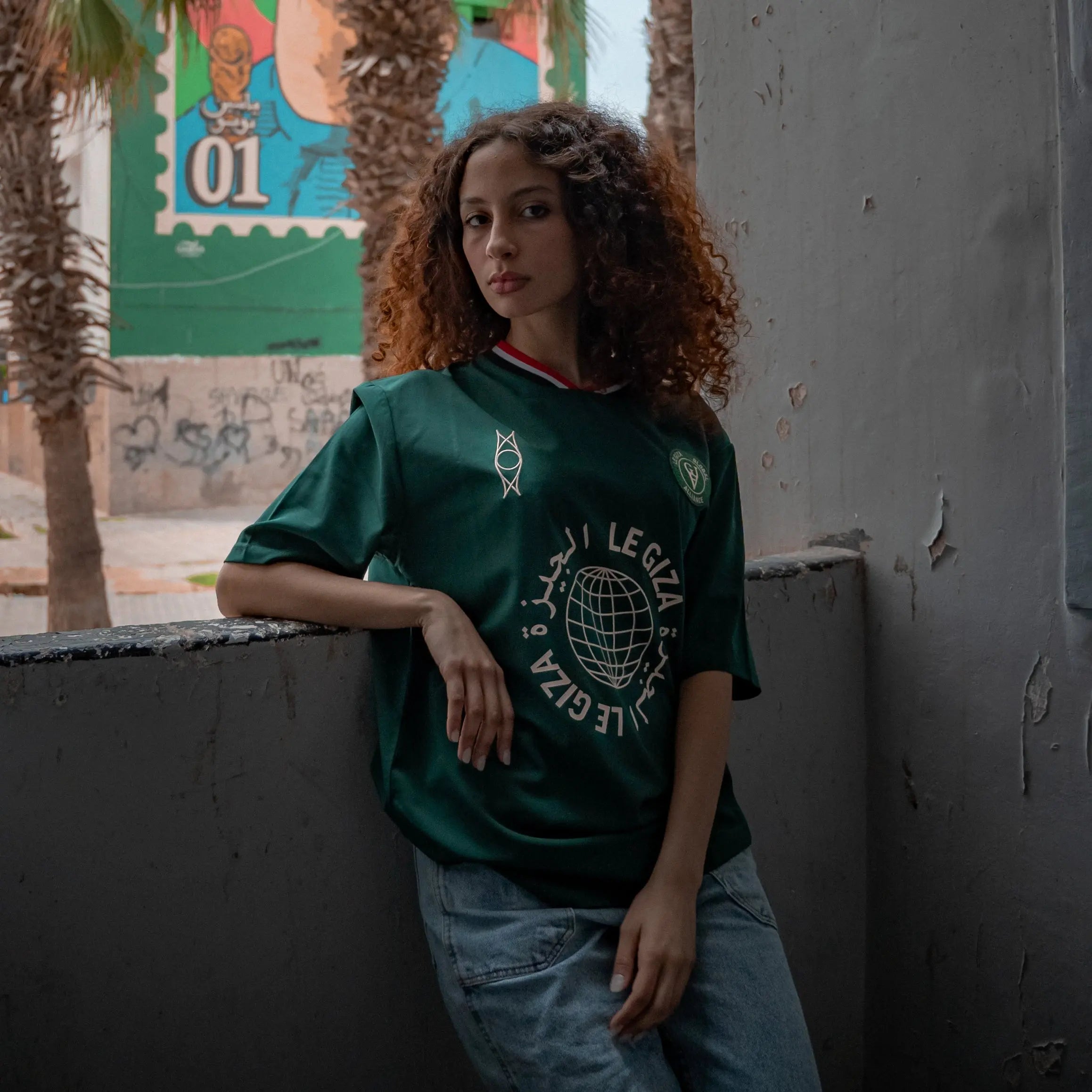 Fatma, 162cm tall, wearing a size Small of the Dark Green Le Giza Football Jersey.