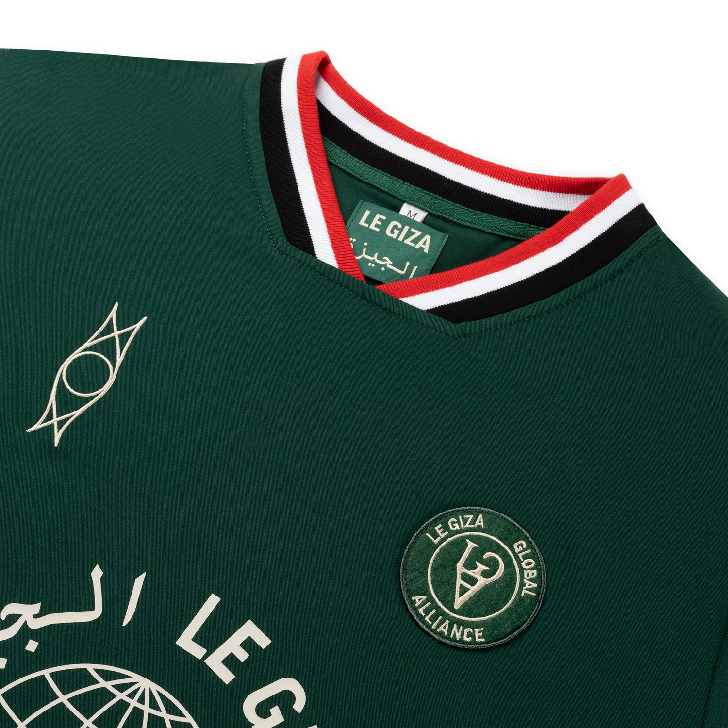 Close-up of twin-eye hieroglyphic embroidery on the Dark Green Le Giza Football Jersey.