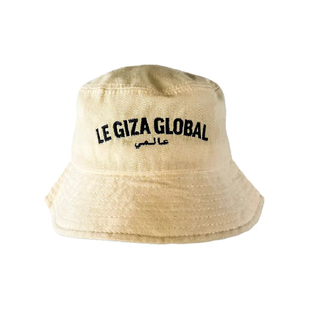 Front view of the Crème Bucket Hat with black Le Giza Global logo embroidery.